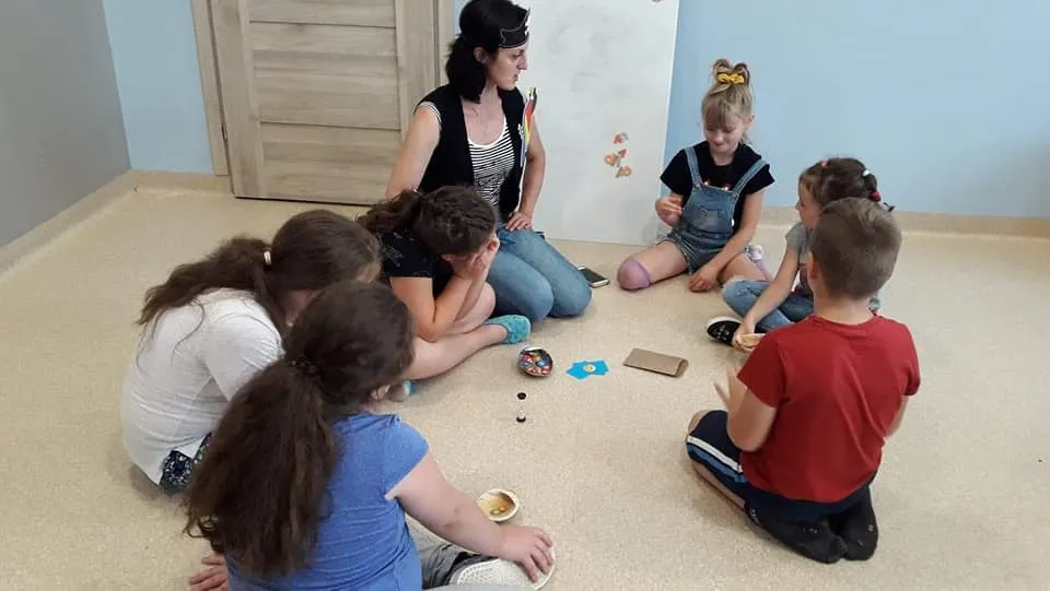 Obraz przedstawia wychowanków rozwiązujących różnego rodzaju zadania. 