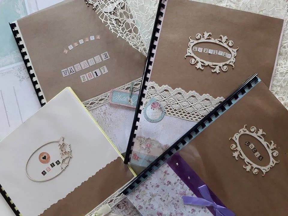 Zdjęcie przedstawia 4 brązowe ręcznie wykonane albumy. 