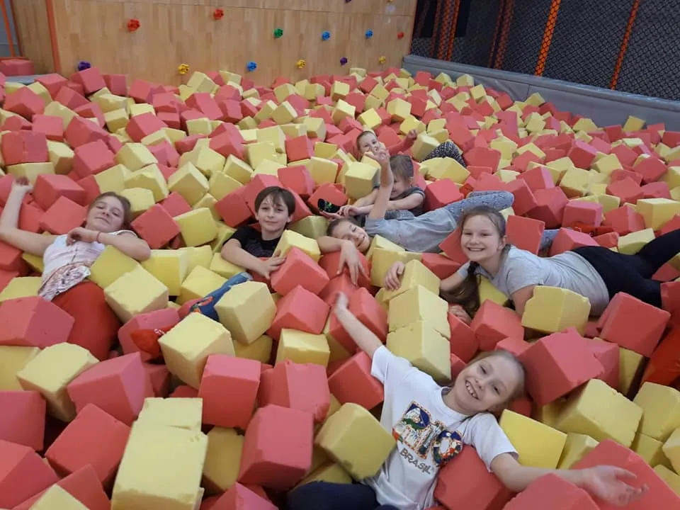 Obraz przedstawia wychowanków w gąbkach parku trampolin.