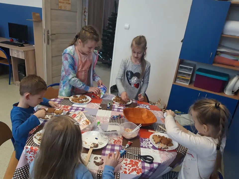 Obraz przedstawia wychowanków SPWD podczas akcji "Fabryczka pierniczka". Podczas tejże akcji wychowankowie wykonują słodkie pierniczki.