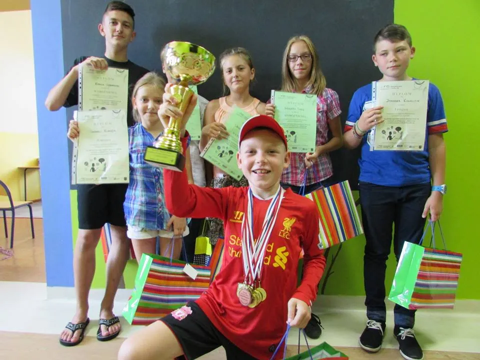 Zdjęcie przedstawia dzieci z placówki z dyplomami oraz nagrodami.