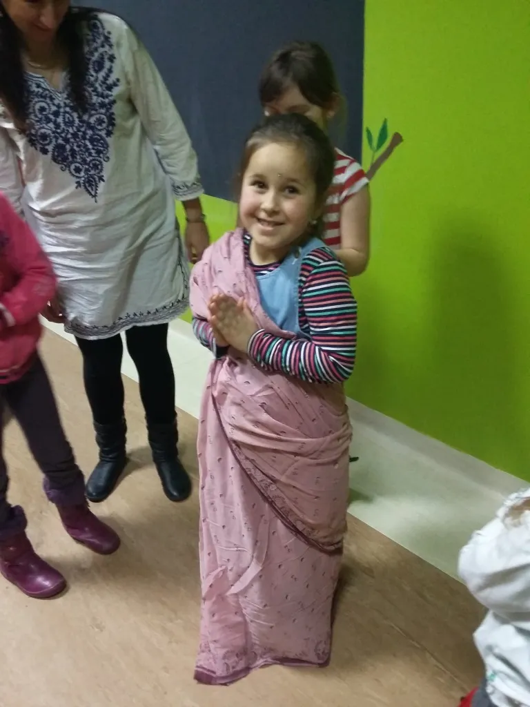 Zdjęcie przedstawia dziewczynkę ubraną w indyjskim stylu w ramach akcji pomocy rówieśnikom w Indiach opisanej w artykule.