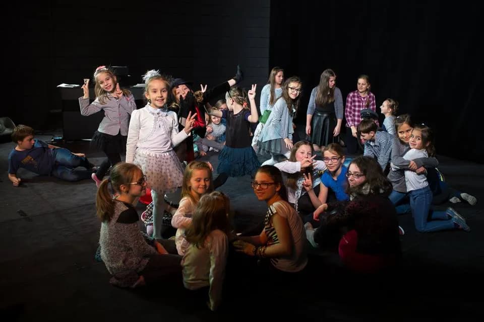 Zdjęcie przedstawia dzieci z placówki podczas przygotowania do występu na scenie teatralnej.