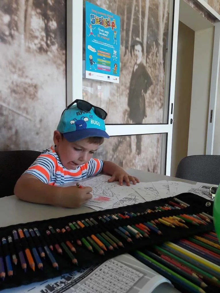 Obraz przedstawia wychowanków uczestniczących w różnego rodzaju konkursach, konkurencjach czy zabawach zorganizowanych przez animatorów.